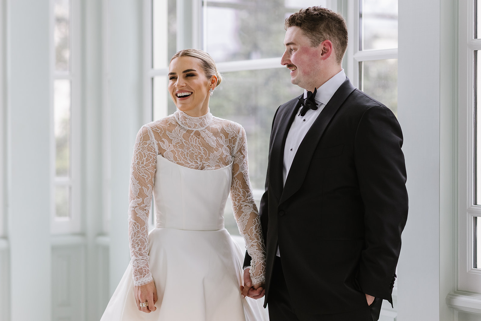 bride and groom share a laugh in a relaxed moment during their wedding portraits at the walters art museum