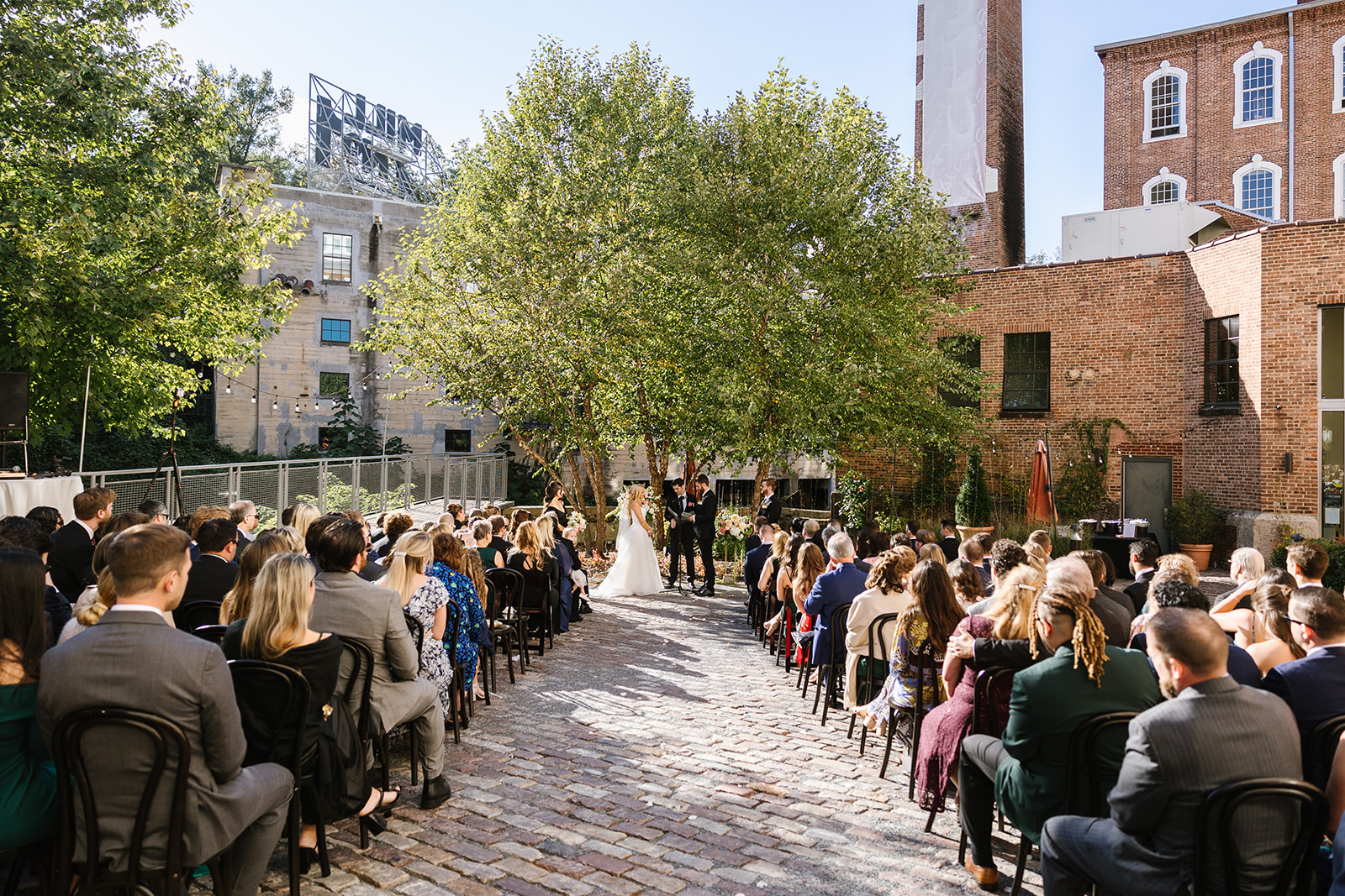 couple getting married outside in the courtyard at the heron room wedding venue
