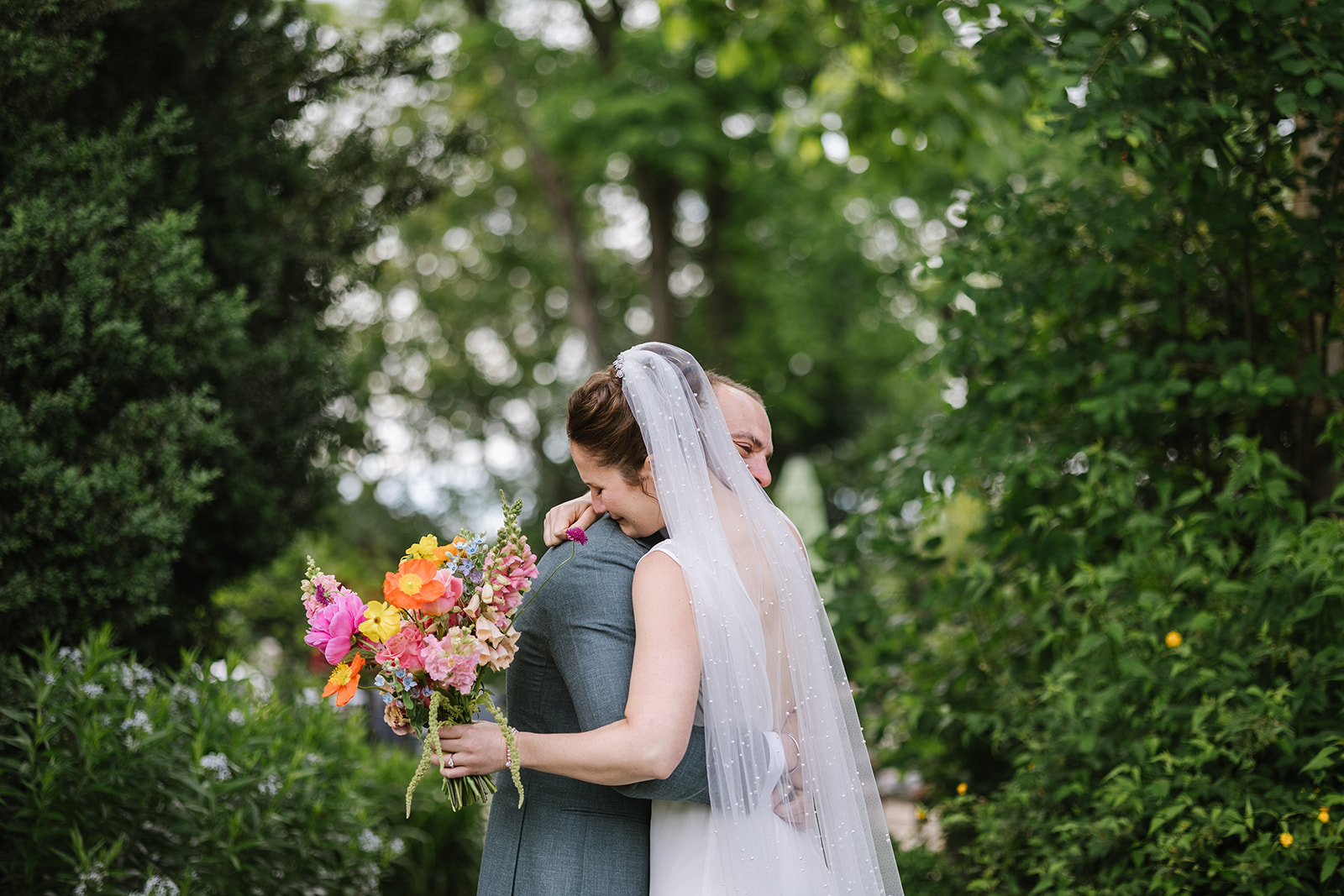 bride and groom embrace in an emotional moment after their first look