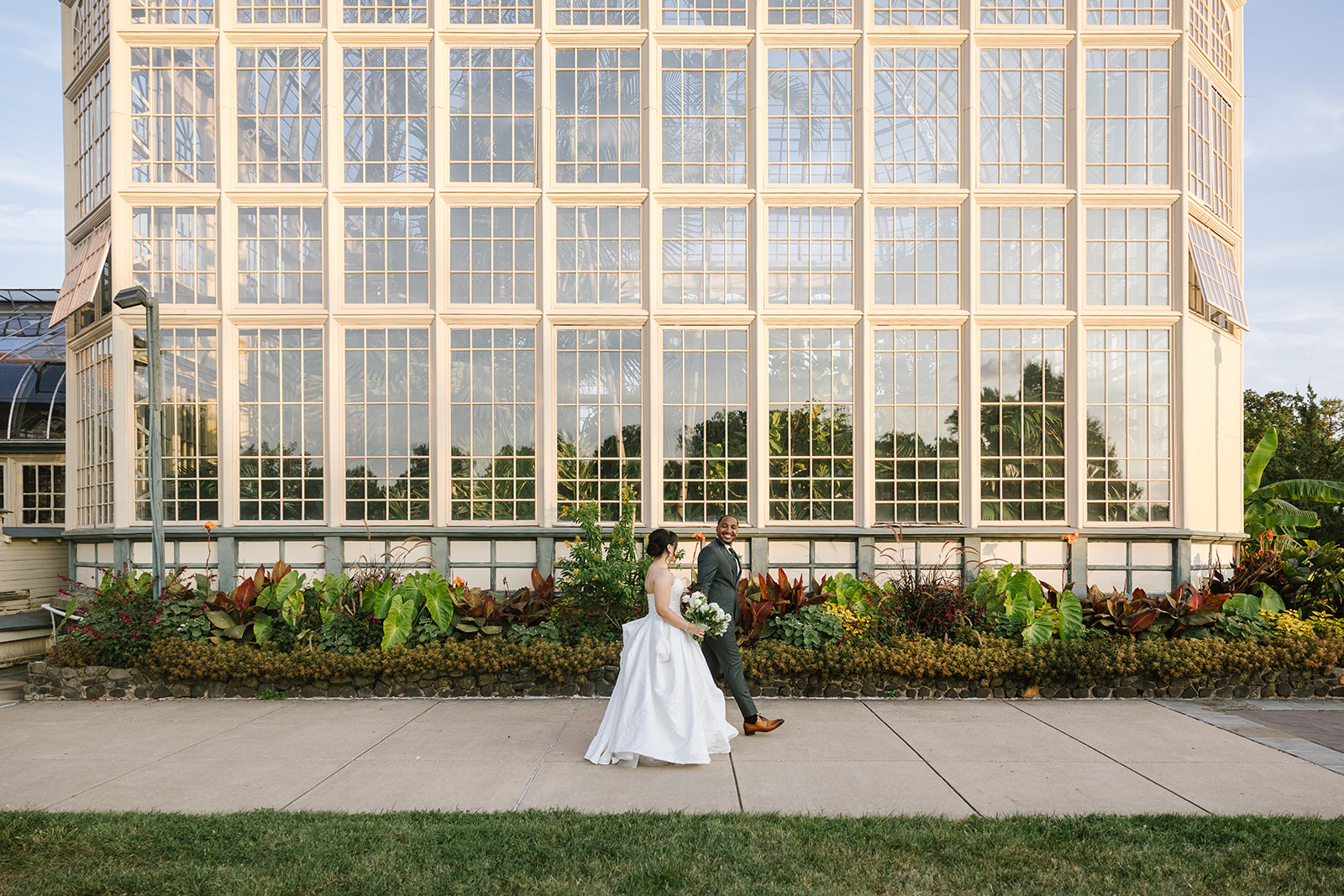 bride and groom walking outside rawlings conservatory