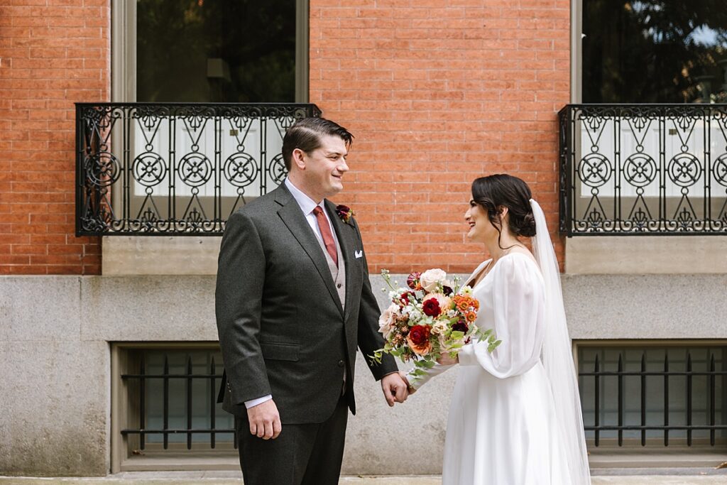 bride and groom holding hands in mt vernon baltimore near peabody library