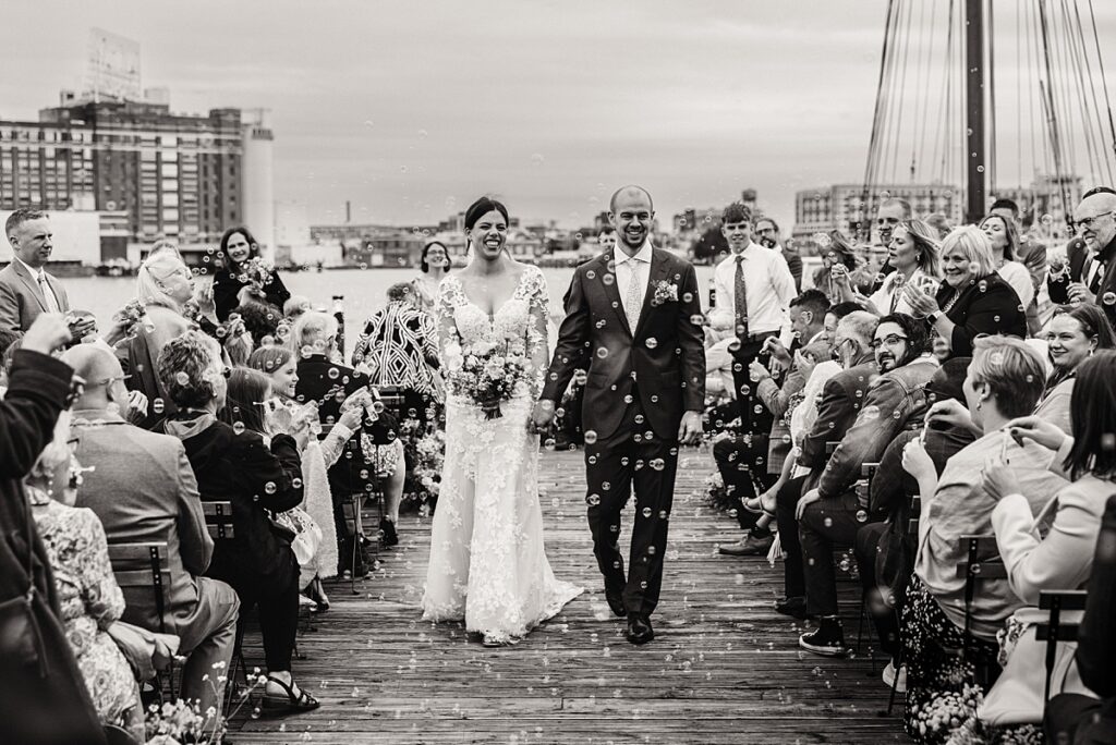 a newly married couple walks down the pier at their wedding ceremony at the frederick douglass maritime park venue